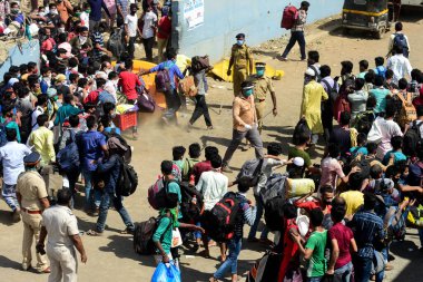 MUMBAI / INDIA - 19 Mayıs 2020: Coronavirus 'un yayılmasına karşı önleyici bir önlem olarak yurda dönüş yolculuklarında özel bir trene bindikleri için Bandra demiryolu terminalindeki göçmen işçiler kalabalığı.