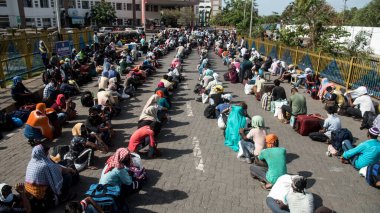 MUMBAI / INDIA - 21 Mayıs 2020: Göçmen işçiler, koronavirüsün yayılmasına karşı önleyici bir önlem olarak ülke çapındaki tecrit sırasında eve dönüş yolculuklarında özel bir trene bindikleri için Bandra tren istasyonunda kuyrukta bekliyor