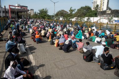 MUMBAI / INDIA - 21 Mayıs 2020: Göçmen işçiler, koronavirüsün yayılmasına karşı önleyici bir önlem olarak ülke çapındaki tecrit sırasında eve dönüş yolculuklarında özel bir trene bindikleri için Bandra tren istasyonunda kuyrukta bekliyor