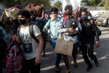 MUMBAI / INDIA - 21 Mayıs 2020: Göçmen işçiler, Coronavirus 'un yayılmasına karşı önleyici bir önlem olarak ülke çapındaki tecrit sırasında eve dönüş yolculuklarında özel bir trene bindikleri için Bandra tren istasyonunda kuyruğa girdiler
