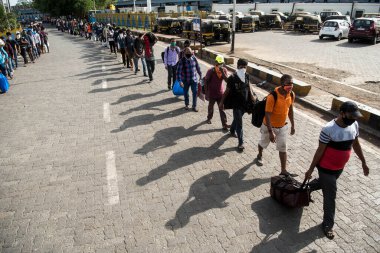 MUMBAI / INDIA - 21 Mayıs 2020: Göçmen işçiler, Coronavirus 'un yayılmasına karşı önleyici bir önlem olarak ülke çapındaki tecrit sırasında eve dönüş yolculuklarında özel bir trene bindikleri için Bandra tren istasyonunda kuyruğa girdiler