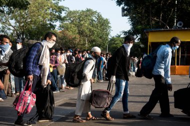 MUMBAI / INDIA - 24 Mayıs 2020: Göçmen işçiler Chhatrapati Shivaji Maharaj demiryolu terminaline dönüş yolunda özel trene bindikleri için kuyruğa girdiler.