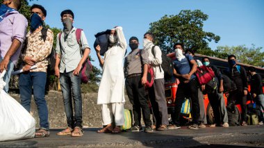 MUMBAI / INDIA - 24 Mayıs 2020: Göçmen işçiler Chhatrapati Shivaji Maharaj demiryolu terminaline dönüş yolunda özel trene bindikleri için kuyruğa girdiler.
