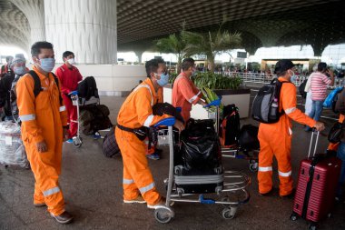 MUMBAI / INDIA - 25 Mayıs 2020: Hükümet ülke çapında tecrit ilan ettikten sonra yurt içi uçuşların devam ettiği ilk günde uçağa binmek üzere Chhatrapati Shivaji Maharaj Havalimanı 'nda kuyrukta bekleyenler.