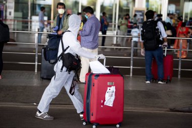 MUMBAI / INDIA - 25 Mayıs 2020: Koruyucu giysi giyen yolcular, hükümet tarafından ülke çapında tecrit altına alındıktan sonraki ilk gün Shivaji Maharaj Havalimanı 'na gelmek üzere uçağa bindiler..