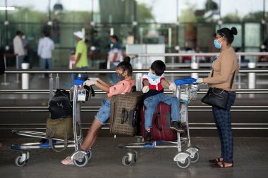 MUMBAI / INDIA - 25 Mayıs 2020: Hükümet ülke çapında tecrit ilan ettikten sonra yurt içi uçuşların devam ettiği ilk günde uçağa binmek üzere Chhatrapati Shivaji Maharaj Havalimanı 'nda kuyrukta bekleyenler.