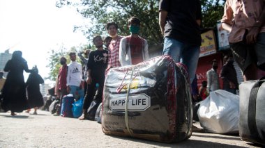 MUMBAI / INDIA - 26 Mayıs 2020: Göçmen işçiler, ülke çapındaki tecrit sırasında ülkeye dönüş yolculuklarına özel bir trene bindikleri için onları tren terminaline götürmek üzere bir otobüse binmek için kuyrukta bekliyor. 