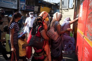 MUMBAI / INDIA - 26 Mayıs 2020: Göçmen işçiler aile üyeleriyle birlikte, önleyici tedbir olarak, ülke çapındaki tecrit sırasında özel bir trene bindikleri için onları tren istasyonuna götürmek üzere sıraya girdiler.
