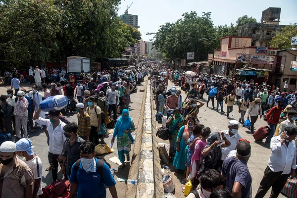 MUMBAI / INDIA - 26 Mayıs 2020: Göçmen işçiler, ülke çapındaki tecrit sırasında ülkeye dönüş yolculuklarına özel bir trene bindikleri için onları tren terminaline götürmek üzere bir otobüse binmek için kuyrukta bekliyor. 