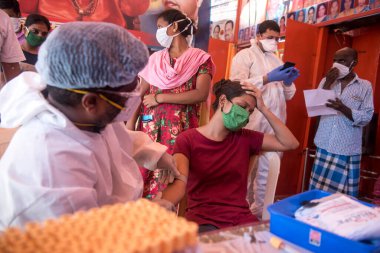 MUMBAI / INDIA - 30 Mayıs 2020: Bir tıp çalışanı COVID-19 Coronavirus için ulusal sero araştırması sırasında Dharavi 'de bir kadının kan örneğini topluyor