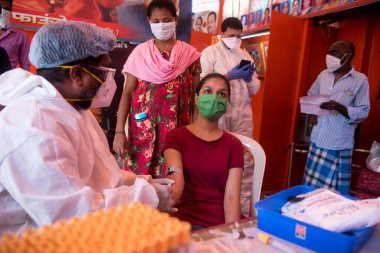 MUMBAI / INDIA - 30 Mayıs 2020: Bir tıp çalışanı COVID-19 Coronavirus için ulusal sero araştırması sırasında Dharavi 'de bir kadının kan örneğini topluyor