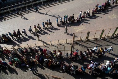 MUMBAI / INDIA - 30 Mayıs 2020: Göçmen işçiler, Coronavirus 'un yayılmasına karşı önleyici bir önlem olarak ülke çapındaki tecrit sırasında eve dönüş yolculuklarında özel trene bindikleri için Lokmanya Tilak tren istasyonuna kuyrukta bekliyor