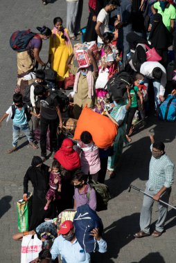 MUMBAI / INDIA - 30 Mayıs 2020: Göçmen işçiler, Coronavirus 'un yayılmasına karşı önleyici bir önlem olarak ülke çapındaki tecrit sırasında eve dönüş yolculuklarında özel trene bindikleri için Lokmanya Tilak tren istasyonuna kuyrukta bekliyor