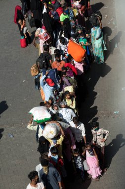 MUMBAI / INDIA - 30 Mayıs 2020: Göçmen işçiler, Coronavirus 'un yayılmasına karşı önleyici bir önlem olarak ülke çapındaki tecrit sırasında eve dönüş yolculuklarında özel trene bindikleri için Lokmanya Tilak tren istasyonuna kuyrukta bekliyor