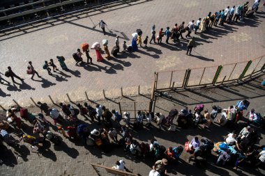 MUMBAI / INDIA - 30 Mayıs 2020: Göçmen işçiler, Coronavirus 'un yayılmasına karşı önleyici bir önlem olarak ülke çapındaki tecrit sırasında eve dönüş yolculuklarında özel trene bindikleri için Lokmanya Tilak tren istasyonuna kuyrukta bekliyor