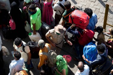 MUMBAI / INDIA - 30 Mayıs 2020: Göçmen işçiler, Coronavirus 'un yayılmasına karşı önleyici bir önlem olarak ülke çapındaki tecrit sırasında eve dönüş yolculuklarında özel trene bindikleri için Lokmanya Tilak tren istasyonuna kuyrukta bekliyor