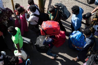 MUMBAI / INDIA - 30 Mayıs 2020: Göçmen işçiler, Coronavirus 'un yayılmasına karşı önleyici bir önlem olarak ülke çapındaki tecrit sırasında eve dönüş yolculuklarında özel trene bindikleri için Lokmanya Tilak tren istasyonuna kuyrukta bekliyor