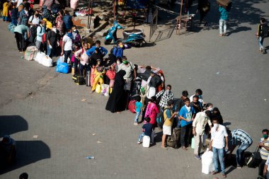 MUMBAI / INDIA - 30 Mayıs 2020: Göçmen işçiler, Coronavirus 'un yayılmasına karşı önleyici bir önlem olarak ülke çapındaki tecrit sırasında eve dönüş yolculuklarında özel trene bindikleri için Lokmanya Tilak tren istasyonuna kuyrukta bekliyor