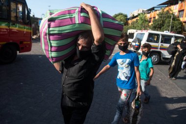 MUMBAI / INDIA - 30 Mayıs 2020: Göçmen işçiler, Coronavirus 'un yayılmasına karşı önleyici bir önlem olarak ülke çapındaki tecrit sırasında eve dönüş yolculuklarında özel trene bindikleri için Lokmanya Tilak tren istasyonuna kuyrukta bekliyor