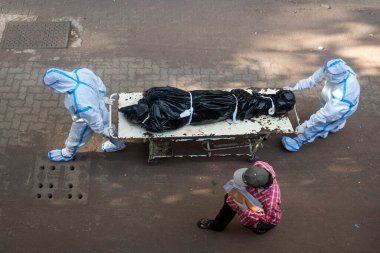 MUMBAI / INDIA - 31 Mayıs 2020: Hastane personeli COVID-19 'dan ölen bir kişinin cesedini Sion hastanesindeki bir morga taşıdı