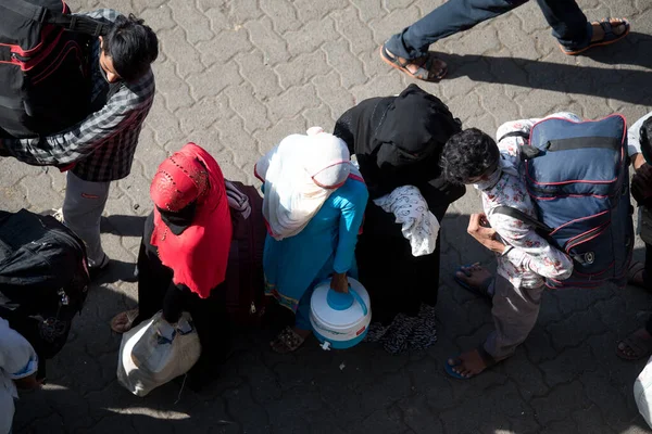 MUMBAI / INDIA - 30 Mayıs 2020: Göçmen işçiler, Coronavirus 'un yayılmasına karşı önleyici bir önlem olarak ülke çapındaki tecrit sırasında eve dönüş yolculuklarında özel trene bindikleri için Lokmanya Tilak tren istasyonuna kuyrukta bekliyor