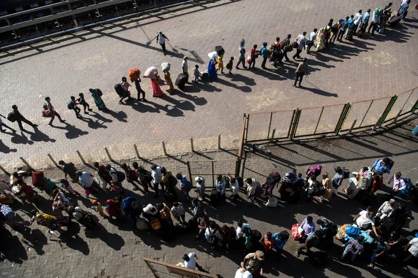 MUMBAI / INDIA - 30 Mayıs 2020: Göçmen işçiler, Coronavirus 'un yayılmasına karşı önleyici bir önlem olarak ülke çapındaki tecrit sırasında eve dönüş yolculuklarında özel trene bindikleri için Lokmanya Tilak tren istasyonuna kuyrukta bekliyor