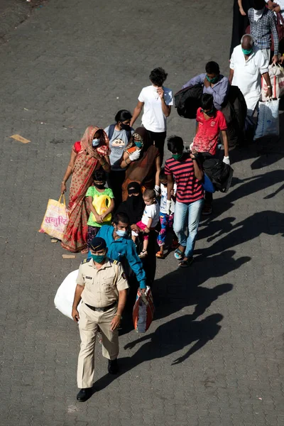 MUMBAI / INDIA - 30 Mayıs 2020: Göçmen işçiler, Coronavirus 'un yayılmasına karşı önleyici bir önlem olarak ülke çapındaki tecrit sırasında eve dönüş yolculuklarında özel trene bindikleri için Lokmanya Tilak tren istasyonuna kuyrukta bekliyor
