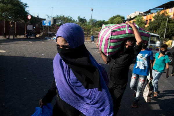 MUMBAI / INDIA - 30 Mayıs 2020: Göçmen işçiler, Coronavirus 'un yayılmasına karşı önleyici bir önlem olarak ülke çapındaki tecrit sırasında eve dönüş yolculuklarında özel trene bindikleri için Lokmanya Tilak tren istasyonuna kuyrukta bekliyor