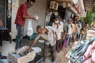 MUMBAI / INDIA - 5 Haziran 2020: Yurt çapındaki tecrit sırasında Matunga 'daki gönüllülerden yiyecek almak için sırada bekleyen evsiz insanlar.