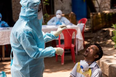 MUMBAI / INDIA - 10 Haziran 2020: Bir tıbbi personel COVID-19 Coronavirus test sürüşünde, COVID-19 Coronavirus salgını sırasında Dharavi 'den örnek alır