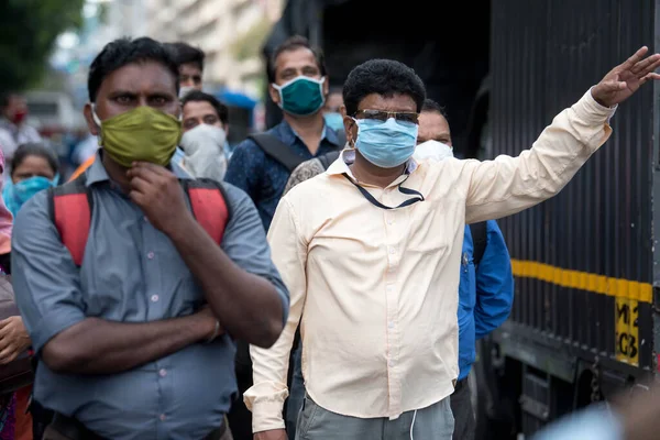 MUMBAI/INDIA- JUNE 10, 2020: Commuters wearing a facemask wait to board a public transport bus in Mumbai. India has begun gradually lifting its restrictions imposed by the government.