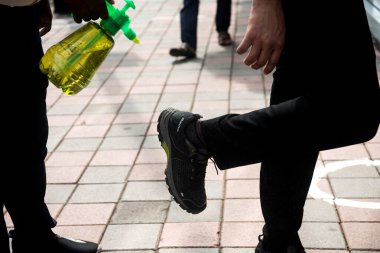 MUMBAI/INDIA- JUNE 17, 2020: A worker disinfects the shoes of a costumer before entering the shop at Dadar as a preventive measure against the spread of the coronavirus, COVID-19.