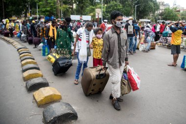 MUMBAI/INDIA - JUNE 17, 2020: Passenger wearing a protective mask arrive at Chhatrapati Shivaji Maharaj railway terminus for boarding a special train back home during a nationwide lockdown as a preventive measure against the COVID-19 coronavirus.