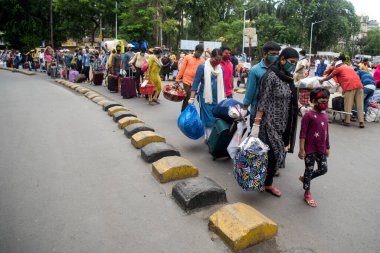 MUMBAI/INDIA - JUNE 17, 2020: Passenger wearing a protective mask arrive at Chhatrapati Shivaji Maharaj railway terminus for boarding a special train back home during a nationwide lockdown as a preventive measure against the COVID-19 coronavirus.