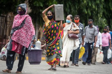 MUMBAI/INDIA - JUNE 17, 2020: Passenger wearing a protective mask arrive at Chhatrapati Shivaji Maharaj railway terminus for boarding a special train back home during a nationwide lockdown as a preventive measure against the COVID-19 coronavirus.