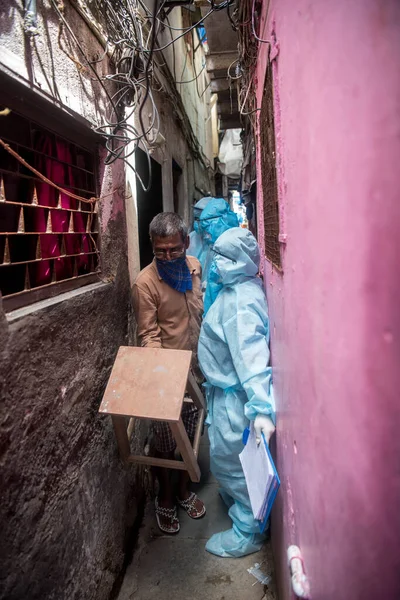 MUMBAI/INDIA- JUNE 17, 2020: Health workers wearing protective gear monitor at the COVID health check up camp at Ramabai colony slum during the COVID-19 Coronavirus pandemic.