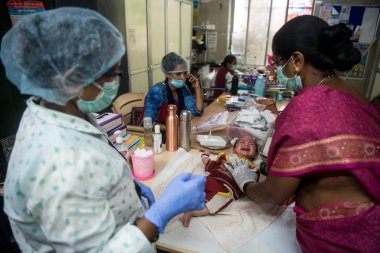 MUMBAI / INDIA- 23 Haziran 2020: Bir tıp çalışanı, COVID-19 Coronavirus salgını sırasında Dharvai gecekondu mahallesindeki bir halk sağlık merkezinde ulusal bir bağışıklık programında bir çocuğa aşı düşürdü.
