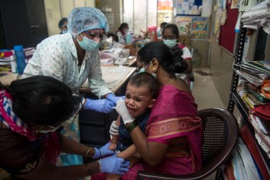 MUMBAI / INDIA- 23 Haziran 2020: Bir tıp çalışanı, COVID-19 Coronavirus pandemisi sırasında Dharvai gecekondu mahallesindeki bir halk sağlık merkezinde ulusal bir immünasyon programı sırasında bir çocuğa aşı enjekte eder.