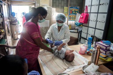 MUMBAI / INDIA- 23 Haziran 2020: Bir tıp çalışanı, COVID-19 Coronavirus pandemisi sırasında Dharvai gecekondu mahallesindeki bir halk sağlık merkezinde ulusal bir immünasyon programı sırasında bir çocuğa aşı enjekte eder.