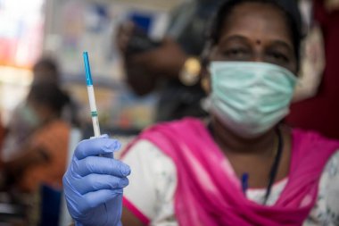 MUMBAI / INDIA - 23 Haziran 2020: Bir tıp çalışanı, COVID-19 Coronavirus salgını sırasında Dharvai gecekondu mahallesindeki bir halk sağlık merkezinde ulusal bir bağışıklık programı sırasında aşı enjeksiyonu hazırlıyor.
