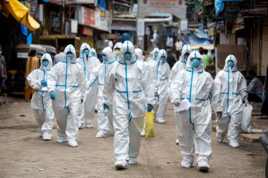 MUMBAI / INDIA - 25 Haziran 2020: COVID-19 Coronavirus salgını sırasında Malad 'da bir Appa Pada gecekondu mahallesinde koruyucu ekipman giyen sağlık görevlileri kapı kapı dolaşarak sağlık kontrolü yapmaya geldiler.