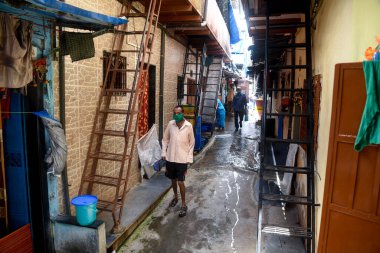 MUMBAI / INDIA - 2 Temmuz 2020: Hükümet koronavirüsün yayılmasını engellemek için tecrit tedbirleri uygularken, insanlar Malad 'daki Appa Pada gecekondu bölgesinde bir ara sokakta yürüyorlar