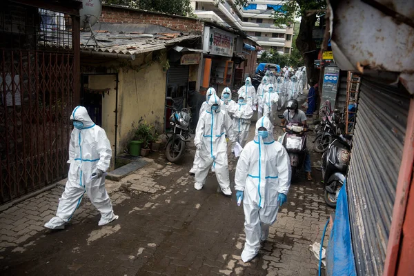 MUMBAI / INDIA - 25 Haziran 2020: COVID-19 Coronavirus salgını sırasında Malad 'da bir Appa Pada gecekondu mahallesinde koruyucu ekipman giyen sağlık görevlileri kapı kapı dolaşarak sağlık kontrolü yapmaya geldiler.