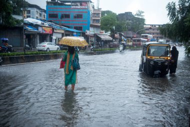 MUMBAI / INDIA - 16 Temmuz 2020: Şiddetli yağmur sırasında insanlar Kurla 'daki sel basmış sularda yürür.