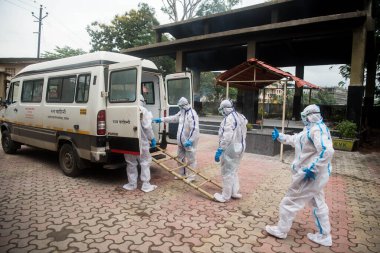 MUMBAI / INDIA - 7 Temmuz 2020: Kişisel koruyucu ekipman giyen cenaze işçileri, COVID-19 'dan ölen bir kişinin cesedini Mumbai yakınlarındaki Panvel' deki bir krematoryuma taşıdılar..
