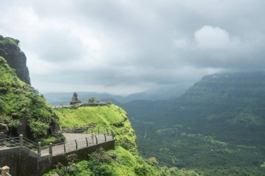 MAHARASHTRA-INDIA - 29 Temmuz 2020: Çelik parmaklıklı Stone Pathway, ayrıca Pune yakınlarındaki Malshej Ghat tepeleri üzerinde gökyüzünde toplanan muson bulutları gördüm.