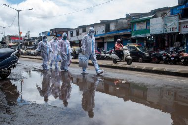 MUMBAI / INDIA - AUGust 3, 2020: Kişisel koruyucu ekipman giyen sağlık çalışanları COVID-19 Coronavirus salgını sırasında Dharavi 'nin gecekondu mahallelerinde kapı kapı dolaşarak kontrol etmeye geldiler.