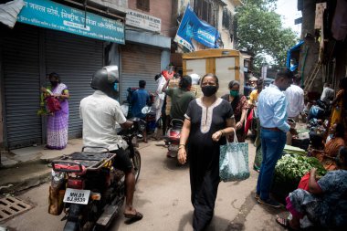 MUMBAI / INDIA - AUGust 3, 2020: COVID-19 Coronavirus salgını sırasında Dharavi gecekondularındaki bir pazarda temel ürünleri satın almak için kalabalık.