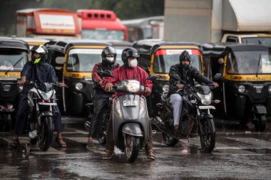 MUMBAI / INDIA - 5 AĞUSTOS 2020: Sakinaka 'da sağanak yağış sırasında motosiklet süren bir adam.