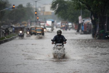 MUMBAI / INDIA - 5 AĞUSTOS 2020: Kurla 'da sağanak yağış sırasında sel basmış bir caddede banliyö aracı.
